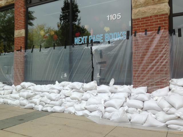 Next Page Books surrounded by plastic and sandbags to protect from flood