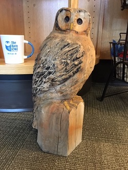 A wooden owl that greets customers at The Barn Owl