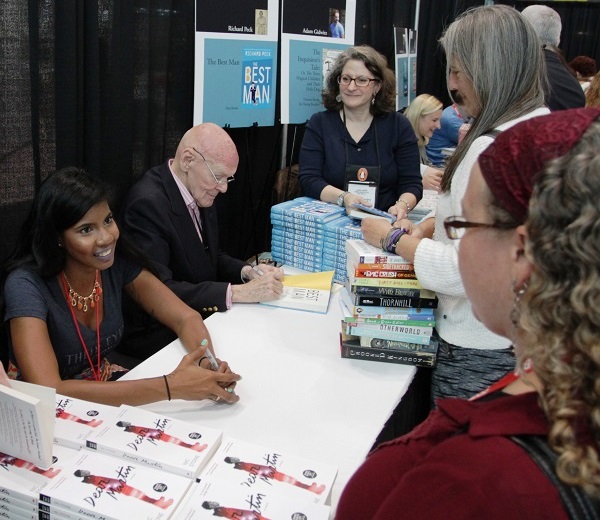 Nic Stone signs copies of “Dear Martin” alongside Richard Peck in the ABA Member Lounge.