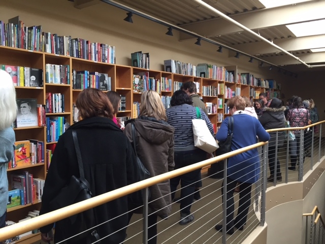 Tour participants peruse titles on display at Consortium Book Sales & Distribution.