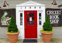 Cricket Book Shop's storefront, which features a bright red door surrounded with white trim.