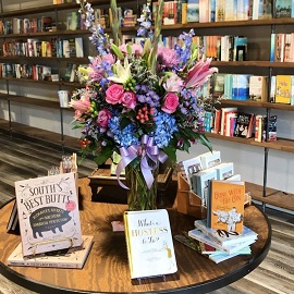 Johns Creek Books and Gifts interior image of books on a table with a bouquet of flowers