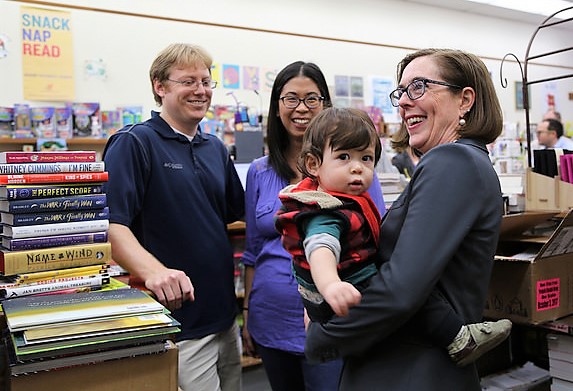 Waucoma Books owners Muir Cohen and Jenny Cohen and son KJ meet with Oregon Gov. Kate Brown. (Photo by Oregon Public Broadcasting)