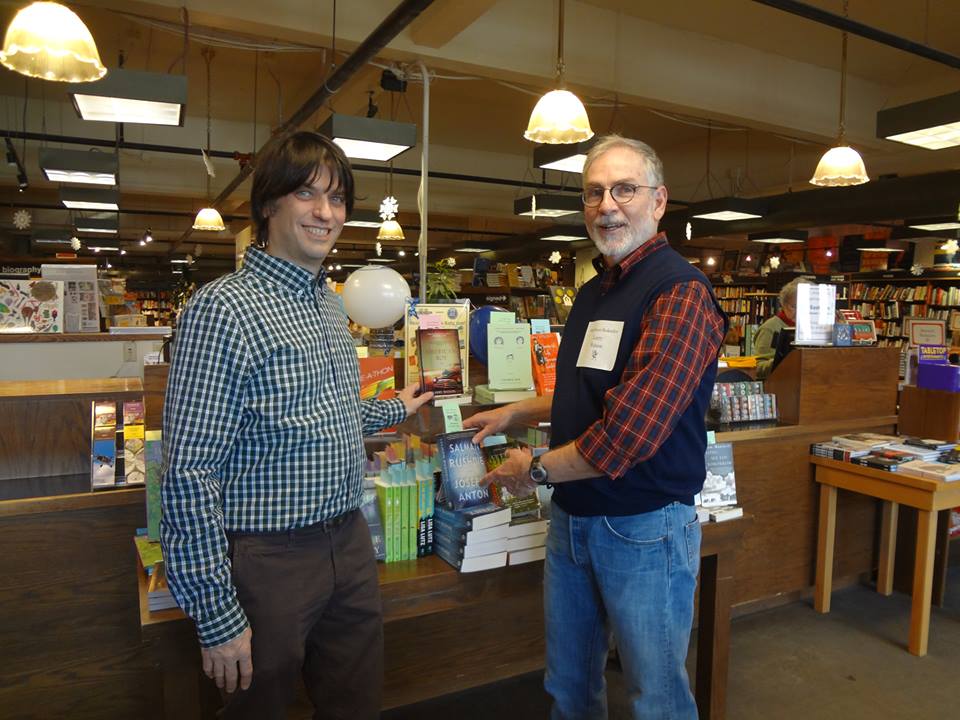 Author Larry Watson lends a hand to Boswell Book Company owner Daniel Goldin.