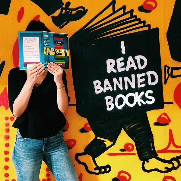Customers took photos of themselves reading banned books in front of Strand Book Store’s mural.