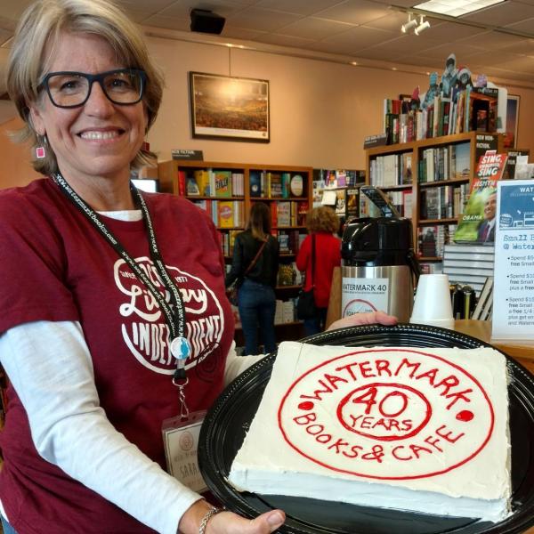 Watermark Books & Cafe owner Sarah Bagby shows off the store's 40th anniversary cake.