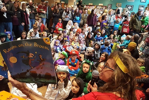 Story-time reading of Room on the Broom with a crowd of kids dressed up in costume at Well-Read Moose