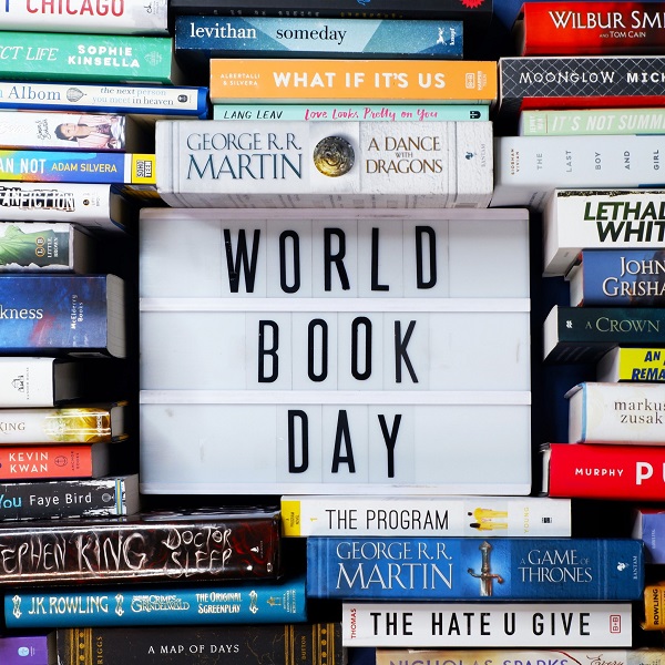 An image of books stacked around a sign that reads World Book Day